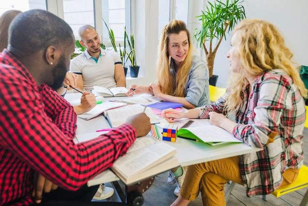 A group of teachers participating in a professional development workshop, actively listening and taking notes. The atmosphere is collaborative and engaging, with facilitators leading discussions and group activities.