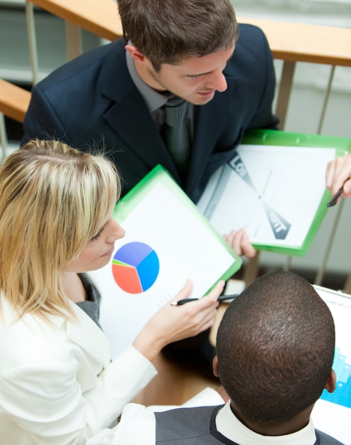 A close-up shot of an evaluation form during an IEP meeting, with hands pointing towards specific sections of the document. The focus is on the data and assessment results.