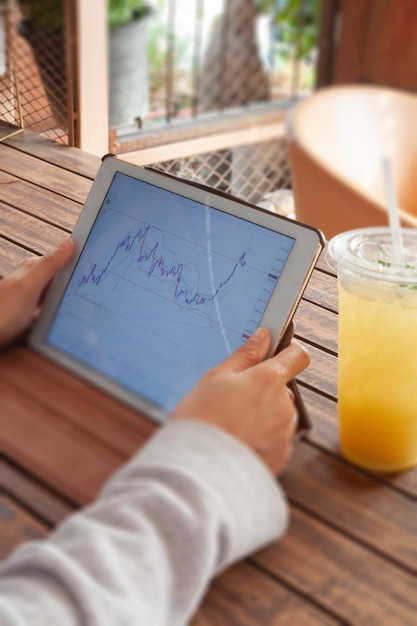 A person joyfully pointing at a growing graph on a digital tablet, set in a modern office environment. The background includes subtle visuals of retirement planning and investment strategies.