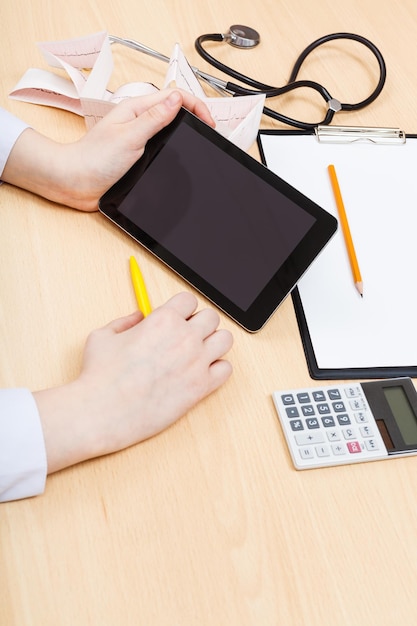 A close-up of a hand holding a calculator, with financial documents and a pen on a desk. The image highlights the financial calculations involved in determining unemployment benefits.