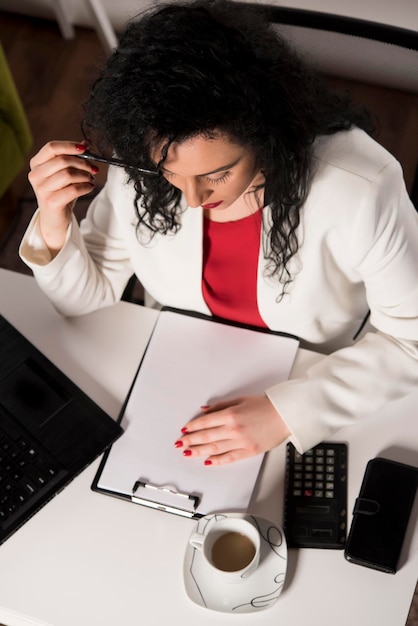 A person sitting at a desk, reviewing documents and using a calculator to estimate their social security benefits and retirement income. The scene emphasizes thoughtful planning and financial literacy.