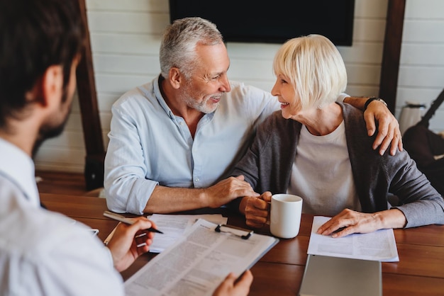 A financial advisor meeting with a retired couple, discussing their social security benefits and retirement plan. The image represents professional guidance and collaborative planning for financial security.