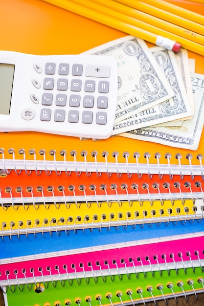 A close-up of textbooks, notebooks, and a calculator, symbolizing the tangible costs associated with education and the need for tax relief.