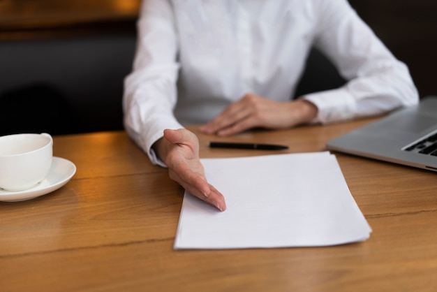 Close up shot of hands pointing to a document at an office desk
