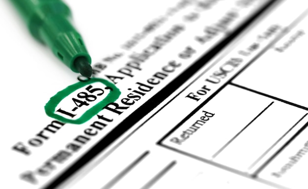 A close-up shot of IRS Form 8936, with a highlighted section indicating where to claim the electric vehicle tax credit. A pen is resting on the form, and a calculator is nearby.