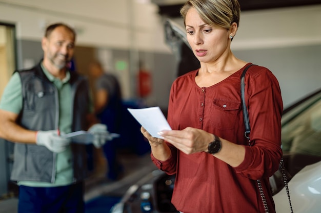 A person carefully reviewing documents related to their electric vehicle purchase, including the sales contract and manufacturer's specifications.