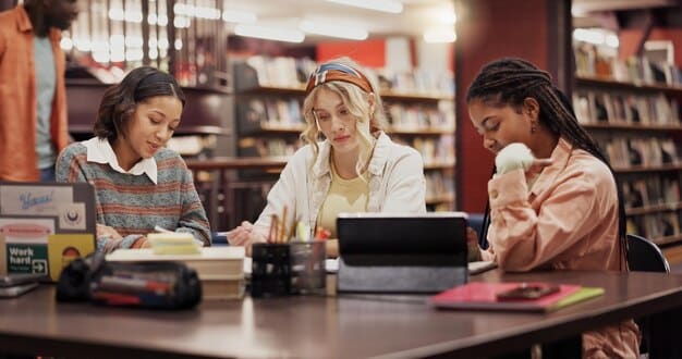 A group of teachers collaborating in a school library, discussing new testing strategies and curriculum adjustments. They are reviewing documents and sharing ideas, demonstrating a proactive approach to implementing the new guidelines. The image emphasizes collaboration and professional development.