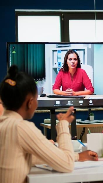 A teacher moderating an online discussion forum on a large screen in a classroom. Students are actively participating using laptops and tablets, demonstrating collaborative learning facilitated by social media.