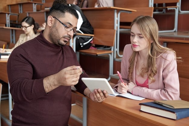 A college professor giving a one-on-one tutoring session to a student in a modern, brightly lit university library. The professor is pointing at a diagram in a textbook, and the student is actively taking notes.
