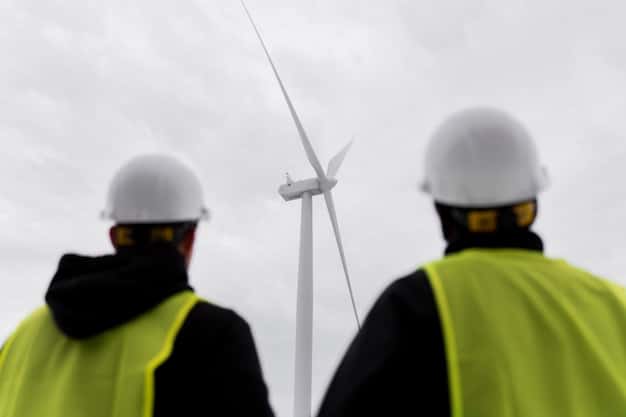 A group of people in hard hats inspecting a wind turbine up close, with a focus on advanced monitoring equipment, illustrating the technological advancements in renewable energy.