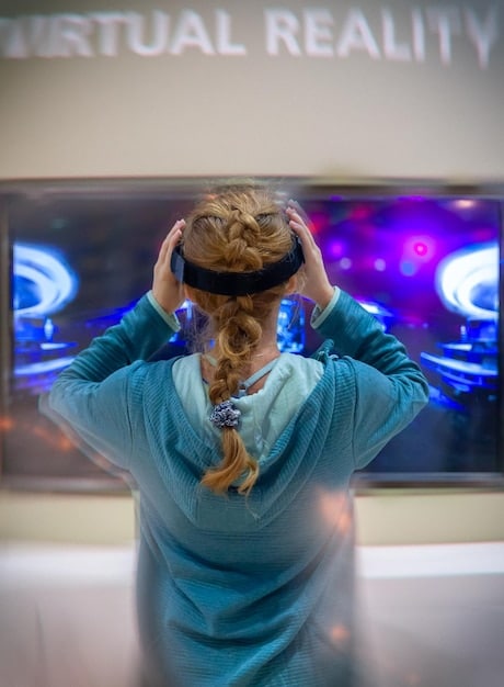 A person wearing a virtual reality headset, interacting with a holographic display showing medical data and simulations, representing telemedicine and digital health solutions.