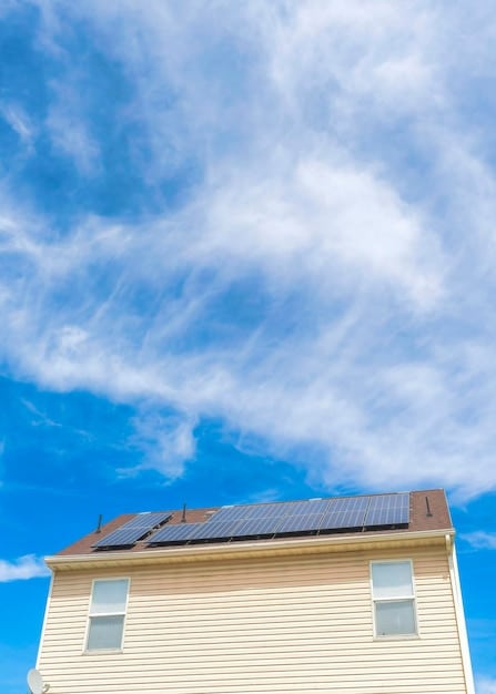 A close-up of a house's roof with brand new solar panels installed, showcasing an energy-efficient upgrade funded by a government grant. The sky is blue and clear in the background.