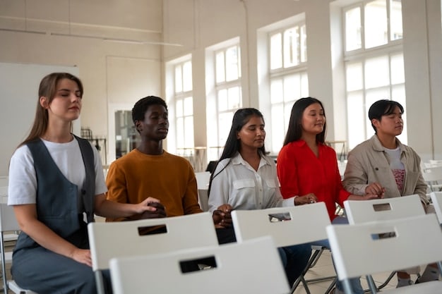 A diverse group of students in a modern classroom setting, engaged in a lecture being delivered by a professor. The students are taking notes on laptops and tablets, and the overall scene conveys a sense of active learning and participation.