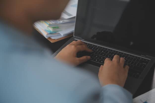 A close-up shot of a person's hands typing on a laptop, highlighting the importance of digital research and online databases in finding unclaimed government money.